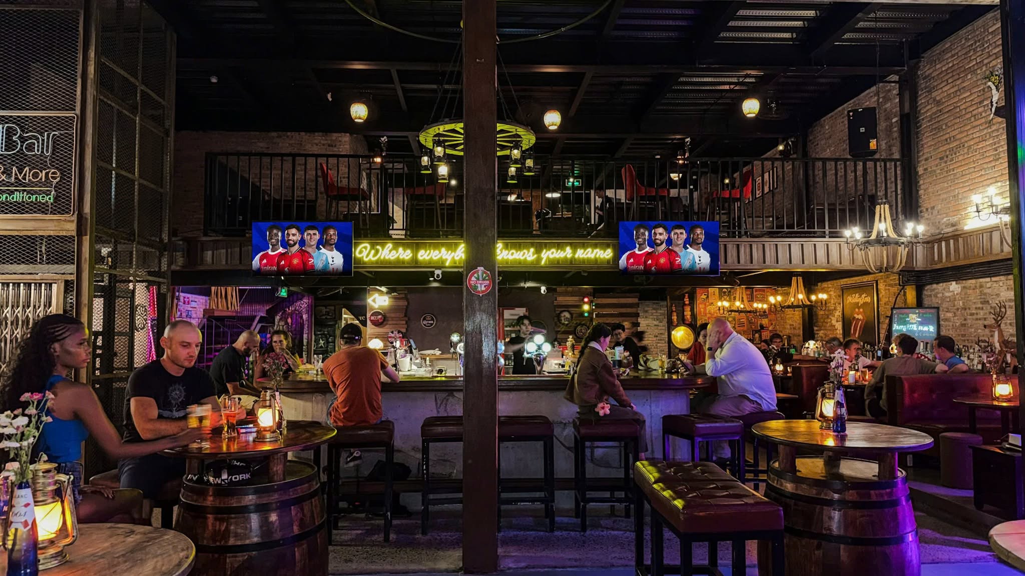Guests enjoying drinks inside the warmly lit Cheers pub