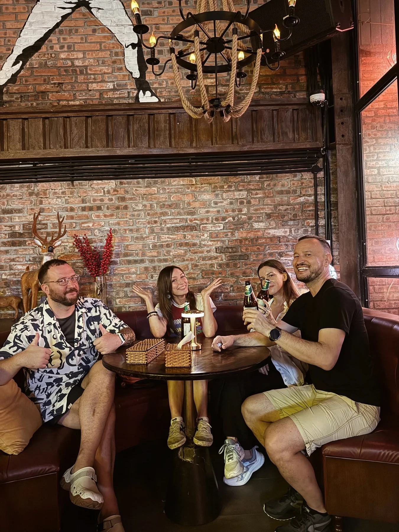 A group of friends sharing drinks around a Cheers table