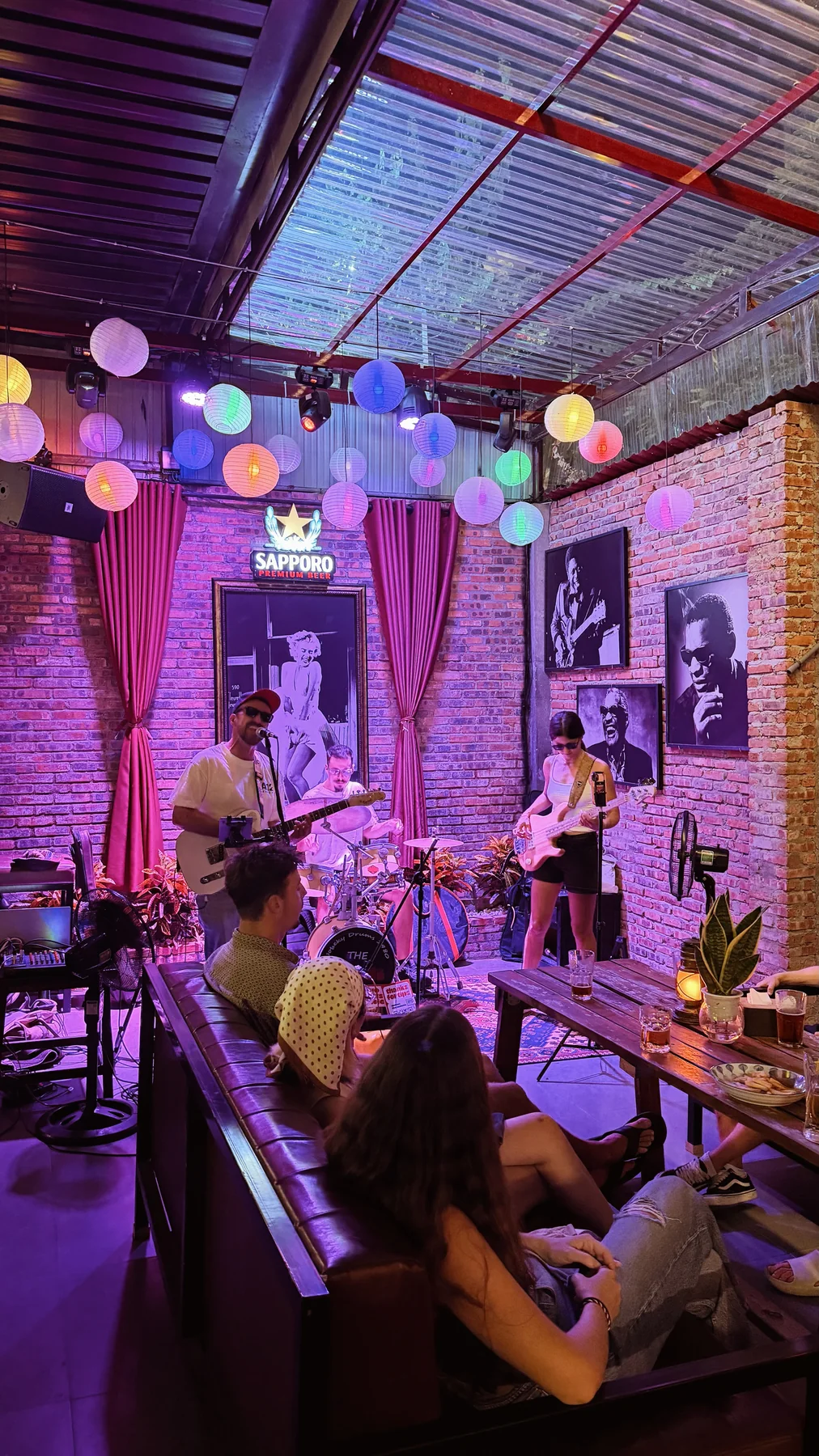 A singer, drummer and bassist performing live at Cheers Pub