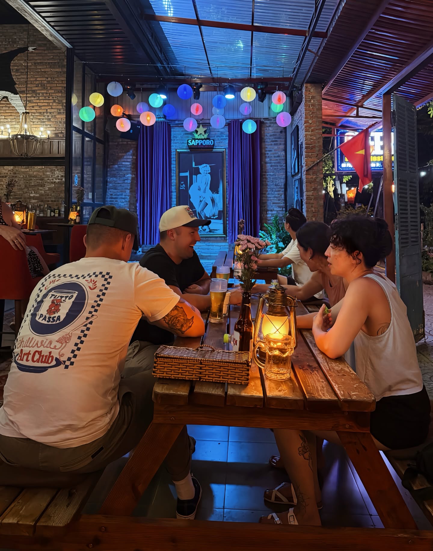 Friends sharing drinks around a wooden table at Cheers